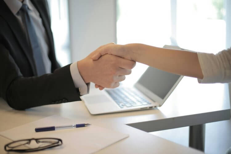 Image of two lawyers shaking hands over a desk